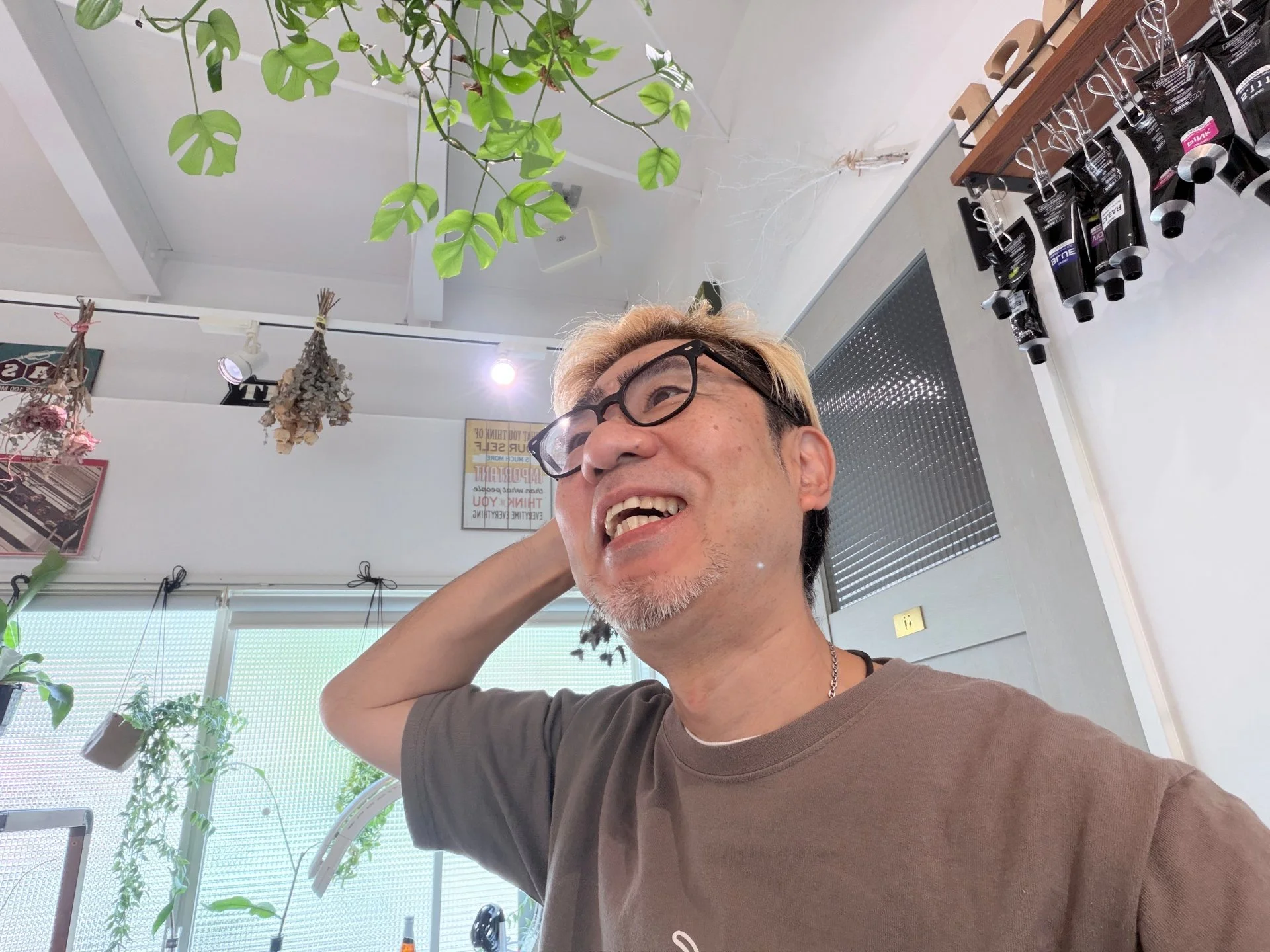 観葉植物のあるサロンで笑顔を見せる136ismのオーナー